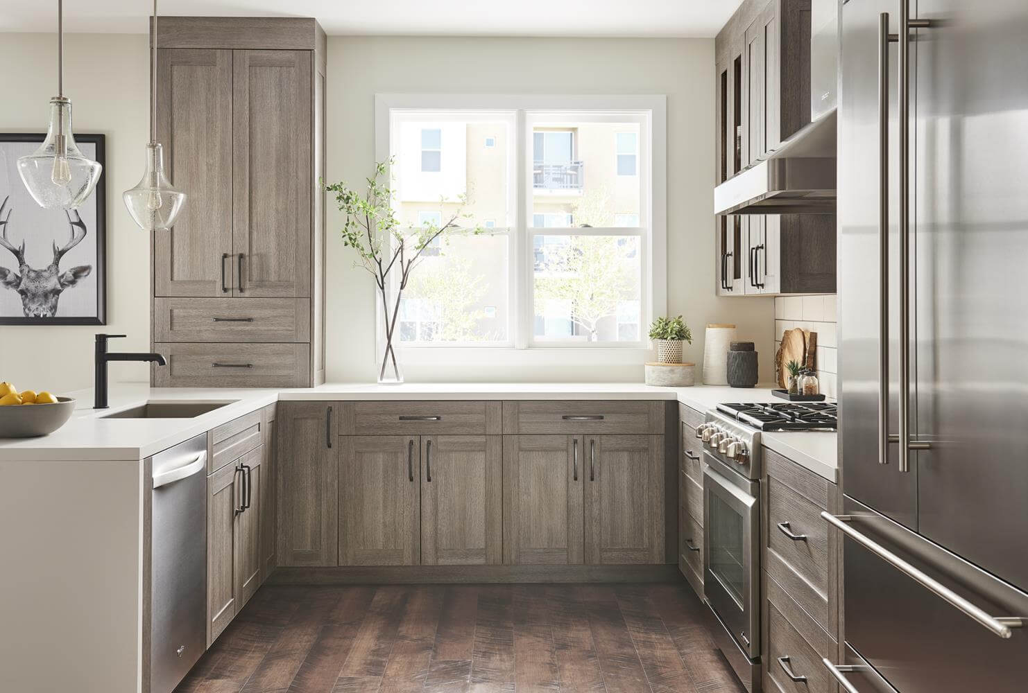 kitchen cabinet shaker style in grey with long stem greenery next to brightly lit window